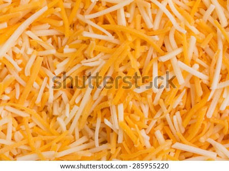 Close view of a shredded white cheddar, sharp cheddar and mild cheddar cheeses.
