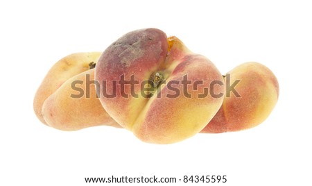 Three saturn variety peaches with two flat and one arranged so the stem is visible on a white background.