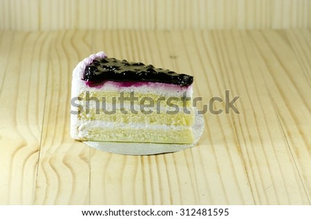 A piece of blue berry cake on wooden floor