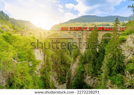 Foto Bild Roter Zug und Frühlingslandschaft bei Sonnenaufgang. Kontext der Frühjahrsreisen