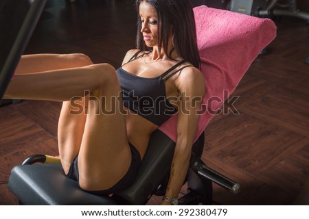 athletic woman in sportswear using a leg press machine