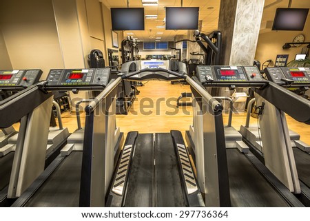 Row of treadmills in modern gym with parquet for running.