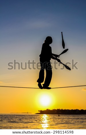 Key West, Florida, United States - April 13, 2012: A tightrope walker tosses of skittles. Show of street artists that takes place every day at sunset