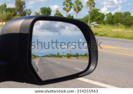 Abstract of the beautiful blue sky in the car mirror on nature road