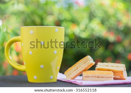 a yellow cup of drink and layer cake