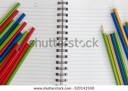 colorful pencil and notebook on white background