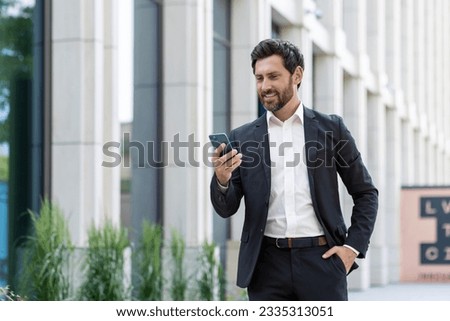 Similar – Foto Bild Mann schaut auf der Straße auf sein Telefon.