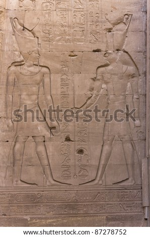 Pharaoh with the Falcon-headed god Horus: engraving on the wall of Edfu temple in Egypt