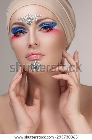 Model with makeup and jewelry, rhinestones in Studio on white background
