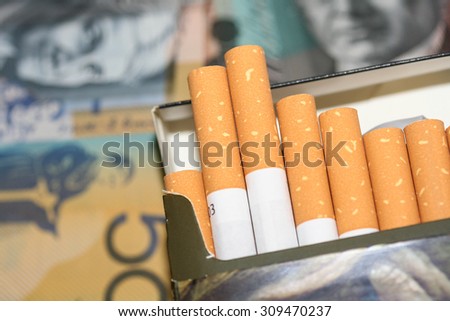 Expensive packet of open cigarettes in front of Australian money.