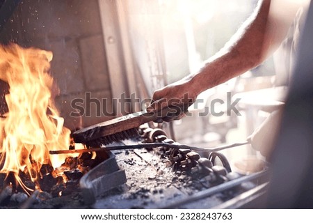 Similar – Image, Stock Photo Focused young blacksmith heating and striking metal on anvil in workshop