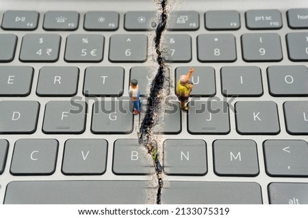 Internet Confrontation.digital divide.The keyboard is split by the cracks that separate the opposites.Social Divide.Divided world.conflicts.cyberbullying. Foto d'archivio © 