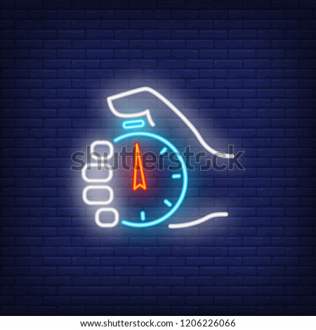 Stopwatch in hand neon sign. Glowing neon hand holding timer on dark blue brick background. Vector illustration for games, completions