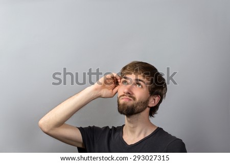 Closeup head shot undecided senior man scratching head thinking looking up isolated gray wall background with copy space