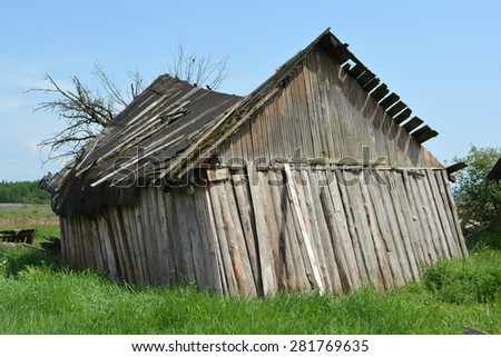 Old rickety wooden barn after the strong wind.
