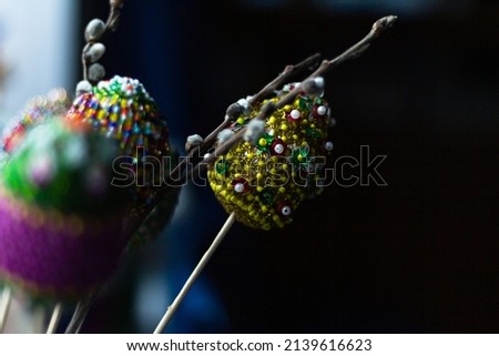 easter colorful eggs decorated with bright color threads and beads with willow, osier tree branch on dark blurry background. Handwork. selective focus, hard times holiday concept Imagine de stoc © 
