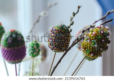 easter colorful eggs decorated with bright color beads with willow, osier tree branch on white blurred background. Handwork. selective focus. spring holiday celebration Imagine de stoc © 