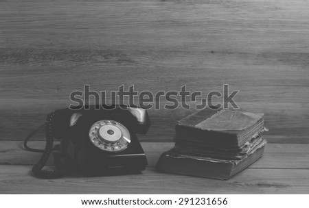 Old books and phone on wood background