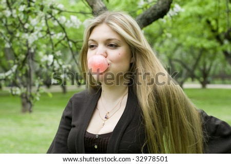 Playful blond girl blowing bubble with bubble gum