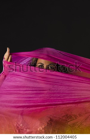 Mysterious eyes of a woman hiding behind a colorful headscarf