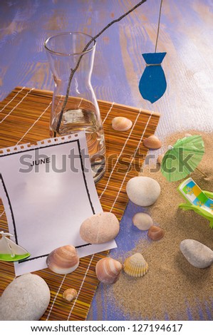 Still life around a tear off calendar page in a beach setting