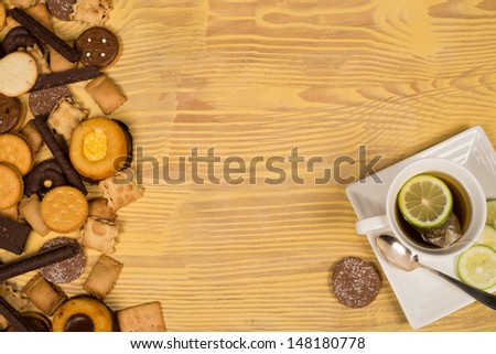 Assorted tea time cookies next to a cup of tea