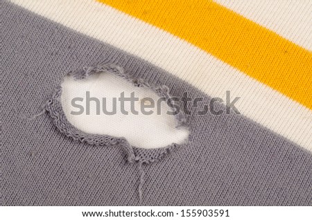 Hole in  the cotton fabric of a shirt