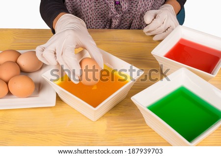 Hands with gloves getting ready to dye Easter eggs