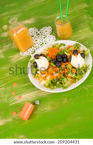 Funny salad decorated with penguins, a way to make vegetables attractive to kids