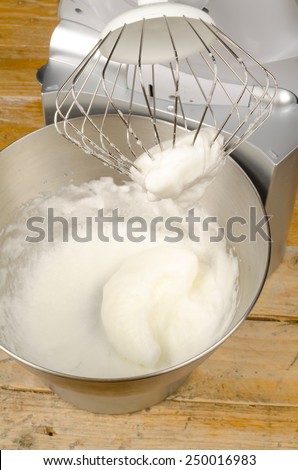 Freshly beaten stiff egg white inside a food processor