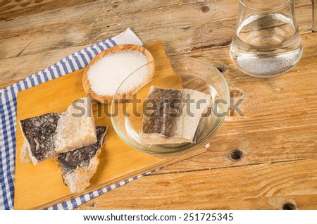 Several pieces of dried cod being desalted in fresh water