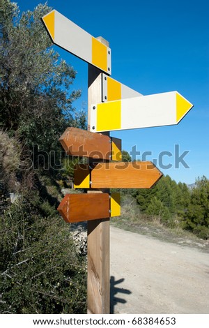 Wooden hiking trail signpost with multiple directions, signs empty for text