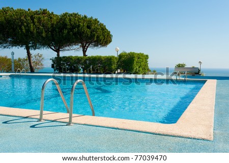 Large rectangular swimming pool against the background of the ocean
