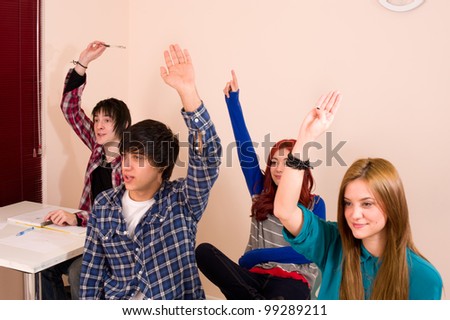 Students with hands raised, a motivated group