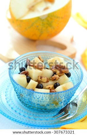 Fruit dessert made of melon, blueberries, caramelized nuts and honey.