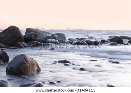 Stony shore with view of Tallinn. Smooth water. Winter shot.