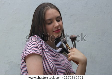 Image, Stock Photo A teenage girl does makeup and shows how to apply blush while recording video for her blog on her smartphone on a tripod at home