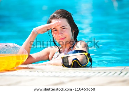 portrait of happy beautiful teen girl at the pool smiling at camera .Teen girl  surrounded by aqua pool water.