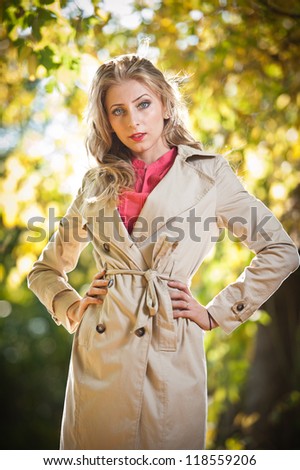 Beautiful elegant woman in autumn park .Young pretty woman at the autumn park. Beautiful woman spending time in park during autumn season .Young pretty woman at the autumn park
