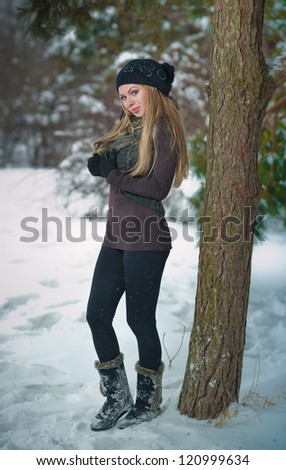 Winter portrait of attractive girl in cap and warm clothes, in park.Beautiful blond hair girl i winter clothes .attractive smiling woman portrait on snow background