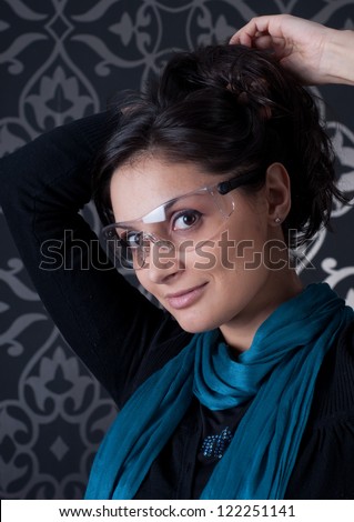 Funky indoor portrait of brunette with blue scarf .Portrait of smiling young woman wearing  glasses.Beautiful woman wearing sunglasses