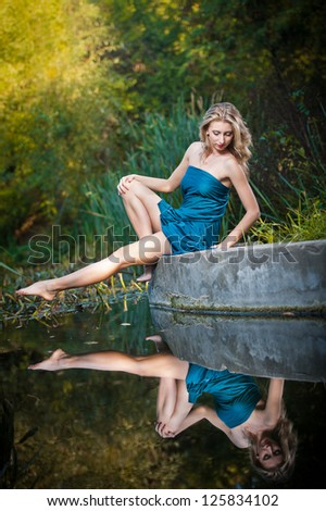 young women in a blue long dress at sunset in a forest .Beautiful young woman in blue dress in garden on sunset . pretty young blonde in a teal green prom dress outdoors in a field