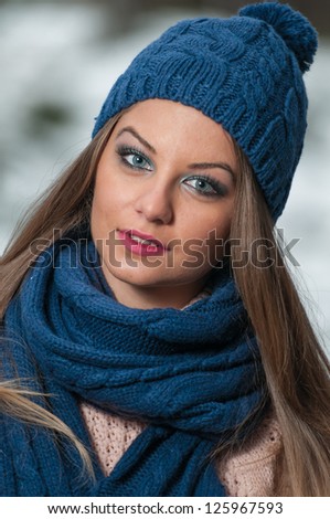 pretty young woman in a winter fashion shot.Winter wild girl on snow.Winter Girl with beautiful make up, and snow flake, forest background.Portrait of attractive girl