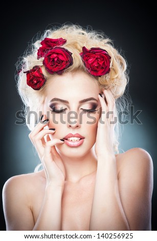 Hairstyle - beautiful sexy female art portrait with roses.Elegance. Genuine Natural Blonde Bride with red Flowers. Artistry.Portrait of a beautiful blonde woman with flowers in her hair. Fashion photo