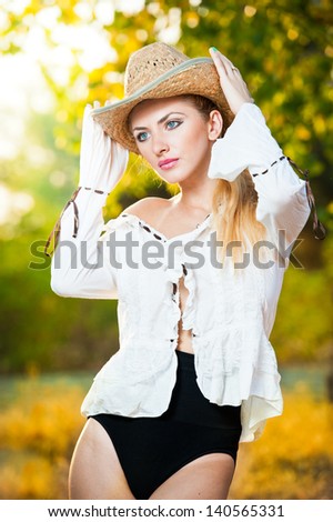 fashion portrait woman with hat and white shirt in the autumn day.Very cute blond woman outdoor with a hat in a autumn forest.Young sensual blonde girl