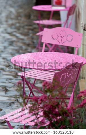 Empty pink tables in the cafe during the rain