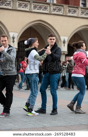 CRACOW, POLAND - MARCH 28, 2015:  the international Flashmob day of rueda de Casino,57 countries , 160 cities. Several hundred persons dance Hispanic rhythms on the Main Square in Cracow