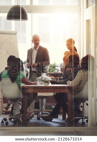 Sharing his business acumen. Shot of a group of coworkers in a boardroom meeting. Photo stock © 