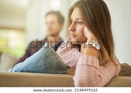 I cant believe were still fighting about this. Shot of an unhappy couple sitting on the couch at home after a fight. Foto stock © 
