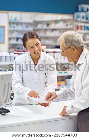 Filling prescriptions with a smile. Shot of a young pharmacist helping an elderly customer at the prescription counter. Imagine de stoc © 